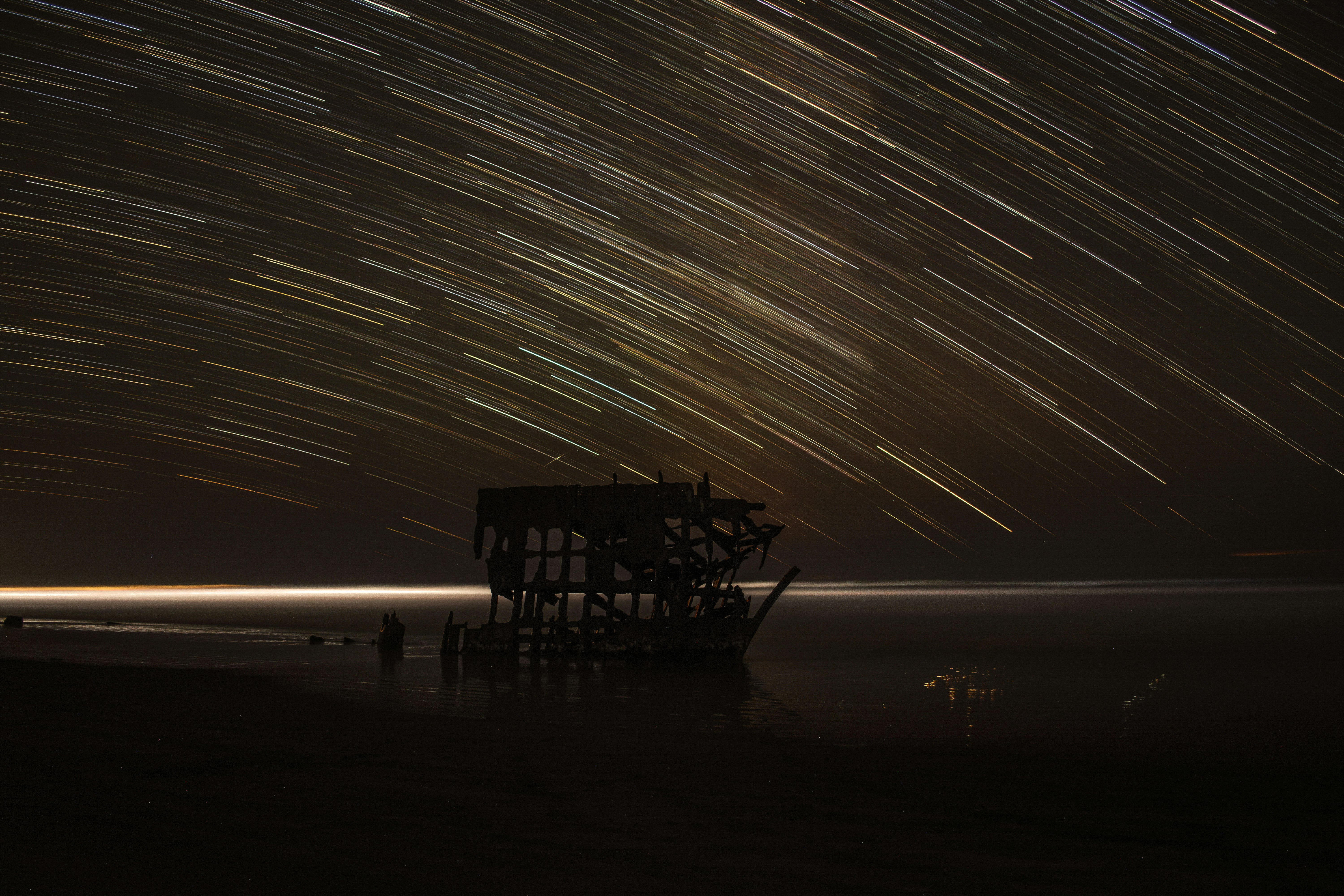 time lapse photography of house with shooting star at night time